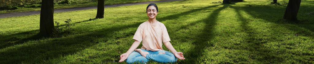 A peaceful traveler comfortably practicing meditation and celebrating Yoga Day with Gaura Travel before boarding their safe flight to India.